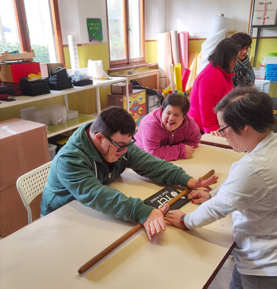 Filippo e Corinna piegano con cura uno dei grembiuli forniti periodicamente dall'azienda Yep tour & event. Un esempio concreto di come la nostra cooperativa contribuisca all'attività produttiva locale. Questa collaborazione rappresenta un'importante opportunità di inclusione lavorativa e valorizzazione delle capacità dei nostri ragazzi.